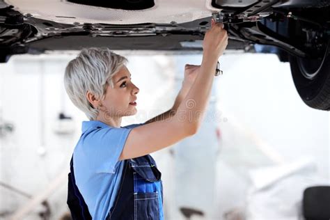 Professional Female Mechanic Holding Tools Fixing Undercarriage Of