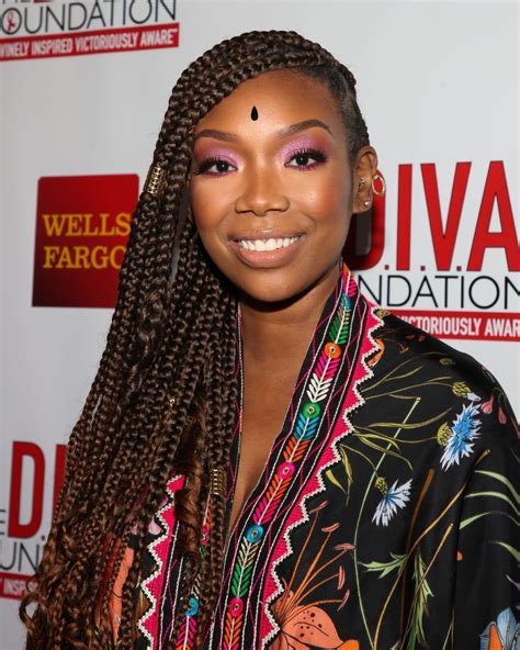 see new photos of moesha star brandy norwood posing with long braids in a striped dress