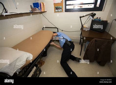 Prison Guard Correctional Officer Searching The Cell Of An Inmate In