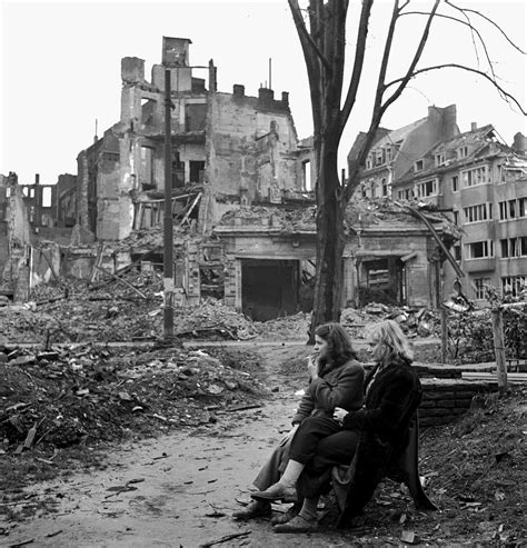 Mit dem direktor und der kuratorin durch köln 1945. Two young German women sit amongst the ruins of Cologne ...