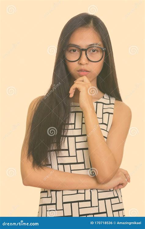 Studio Shot Of Young Asian Teenage Nerd Girl Thinking Stock Photo