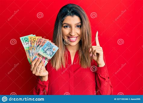 Beautiful Brunette Woman Holding Australian Dollars Pointing Finger Up With Successful Idea