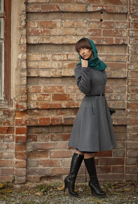 Sad Young Fashion Woman In Coat Looking Back Near Brick Wall Stock