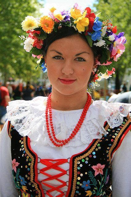 A Woman With Flowers In Her Hair Is Wearing A Colorful Dress And Beads On Her Head
