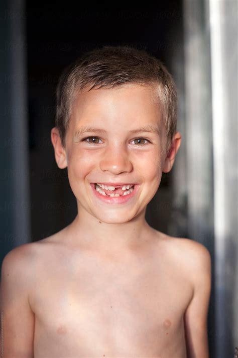 Smiling Boy With Missing Teeth In Doorway By Stocksy Contributor