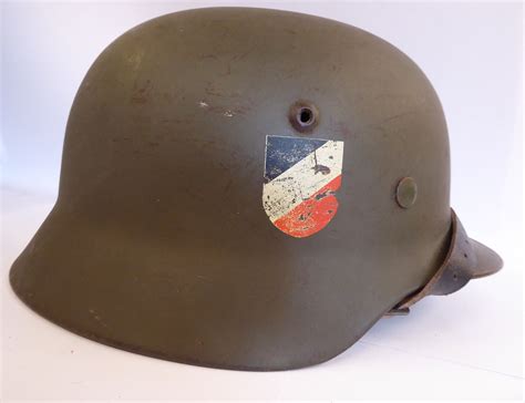 A World War Ii German Army Steel Helmet In Green With Two Decals