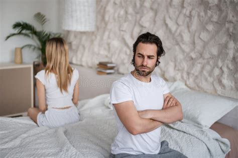 Unhappy Young Couple Having Relationship Problems Sitting On Opposite