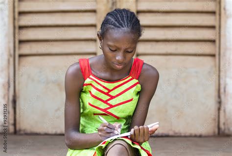 Portrait Of African School Girl Writing Outside Her Classroom A