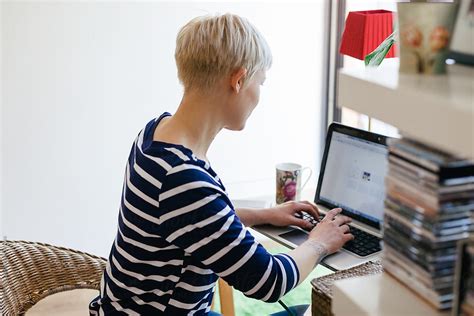 Side View Of A Blonde Woman Working With Her Laptop At Home By Stocksy Contributor