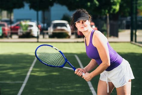 Женщина спортсменка играющая на теннисном корте Бесплатно Фото