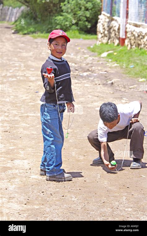 GUATEMALA CAPELLANIA joven indígena Maya Quiché muchachos jugando con una peonza o trompo