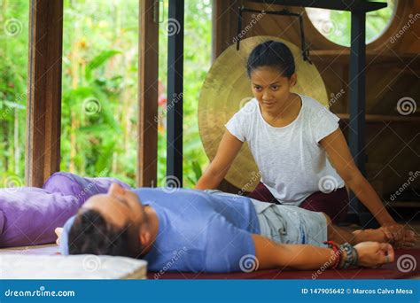 Young Beautiful And Exotic Asian Balinese Wellness Therapist Giving Body Thai Massage To