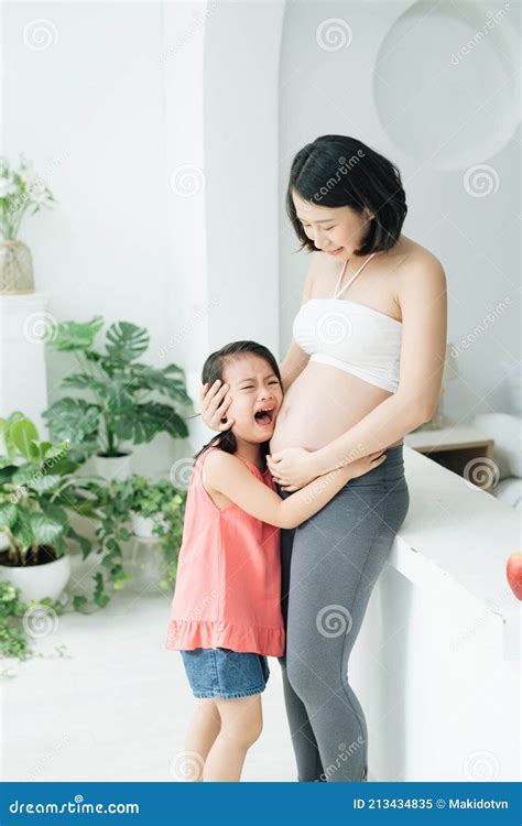 Little Asian Girl Crying With Pregnant Mother Standing In Background Stock Image Image Of