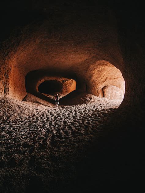 Person In Rocky Sandy Cave With Rough Terrain · Free Stock Photo