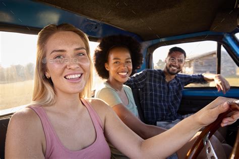 Portrait Of Group Of Friends On Road Trip Driving In Cab Of Pick Up