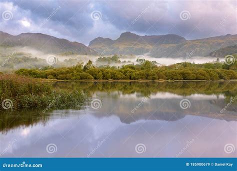Peaceful Misty Morning With Perfect Reflections In Lake And Mountain