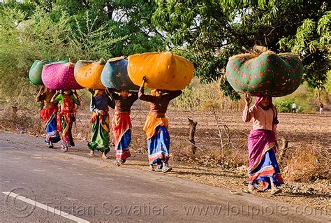 women in sari carrying bags on their head india