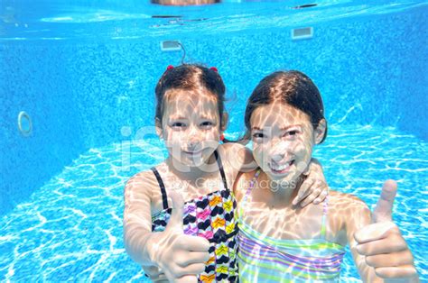 Kids Swim In Pool Underwater Girls Swimming And Having Fun Stock Photo