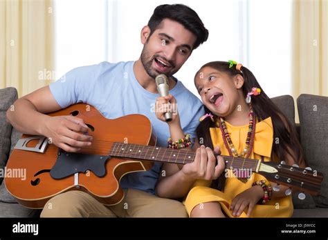 Father And Daughter Singing While Playing Guitar Stock Photo Alamy