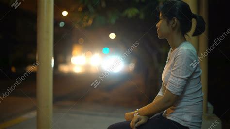 Young Asian Girl Waiting At Bus Stop In Night City Stock Video Footage