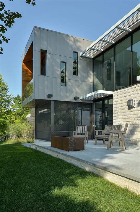 Glass Lake House Features Modern Silhouette Of Earthy