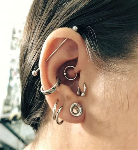 A Woman S Ear With Three Different Piercings Attached To The Back Of