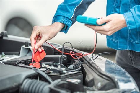 Car Electrician Or Mechanic Checks Voltage In Car Battery Inside The