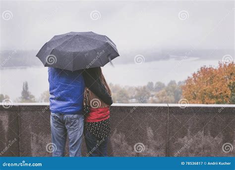 Romantic Couple Hugging In The Street Standing Under An Umbrella Stock