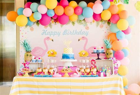 A Birthday Party With Flamingos Pineapples And Cake On A Table