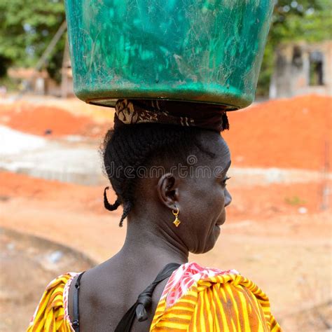 unidentified local woman in colored dress carries a bucket on h editorial image image of west