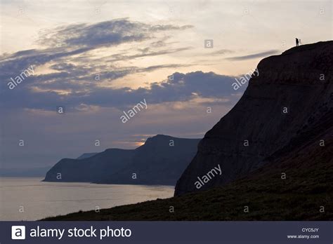 A Photographer Views The Sunset From A Cliff Top On The Jurassic Coast