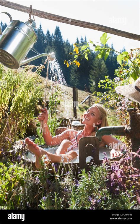 Austria Salzburg Flachau Young Woman Taking Bath With Watering Can