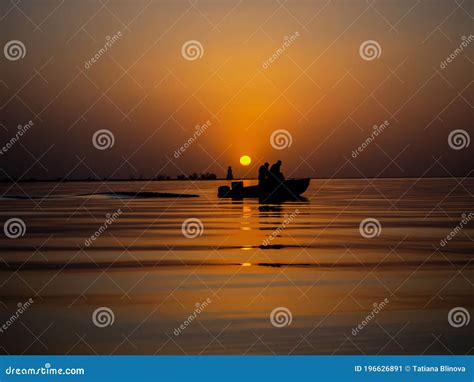 Fishermen In A Fishing Boat On Background Of A Golden Sunset On Sea