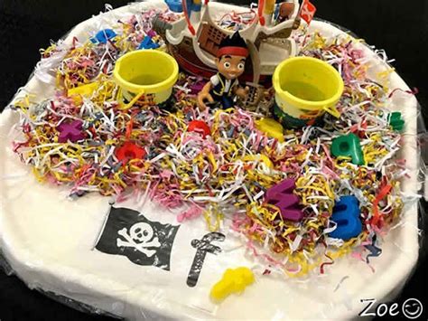 A Pirate Themed Birthday Cake With Sprinkles And Toys On Its Plate