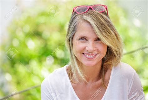 Portrait Of Charming Blond Woman Of Middle Aged Smiling In Glasses Stock Photo Picture And