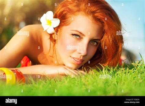 Portrait Of Cute Calm Girl Lying Down On Fresh Green Grass With