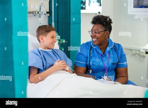 Female Nurse Talking With Boy Patient In Hospital Room Stock Photo Alamy