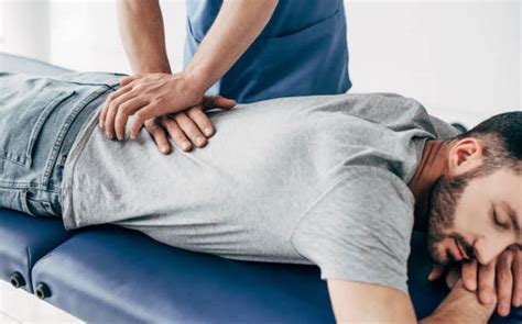 Chiropractor Massaging Back Of Man On Massage Table In Hospital In Touch Physiotherapy Singapore