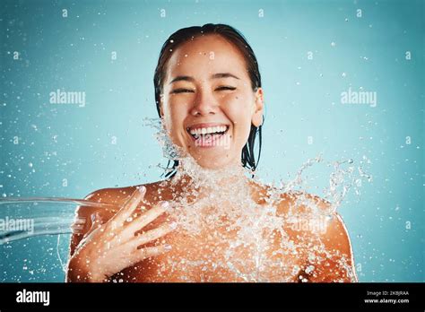 Happy Water Splash And Woman In Studio For Skincare Cleaning And Beauty On A Blue Background