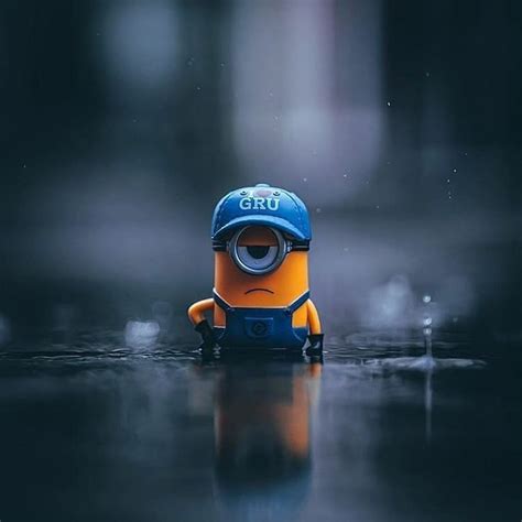 A Minion With A Blue Hat On Its Head Sitting In The Rain