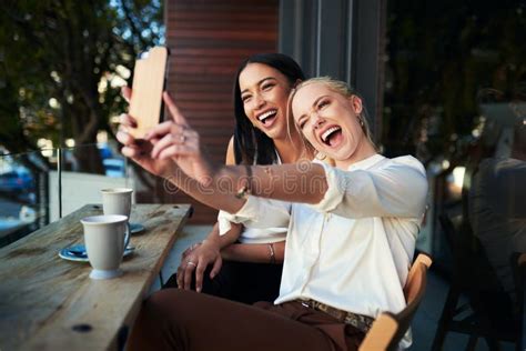 Coffee Shop Selfies Are The Best Shot Of Two Young Women Taking A Selfie While Sitting At A