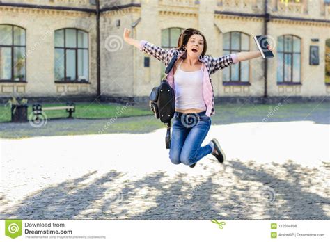 Excited Happy Joyful Female Student Jumping With Book In Her Han Stock