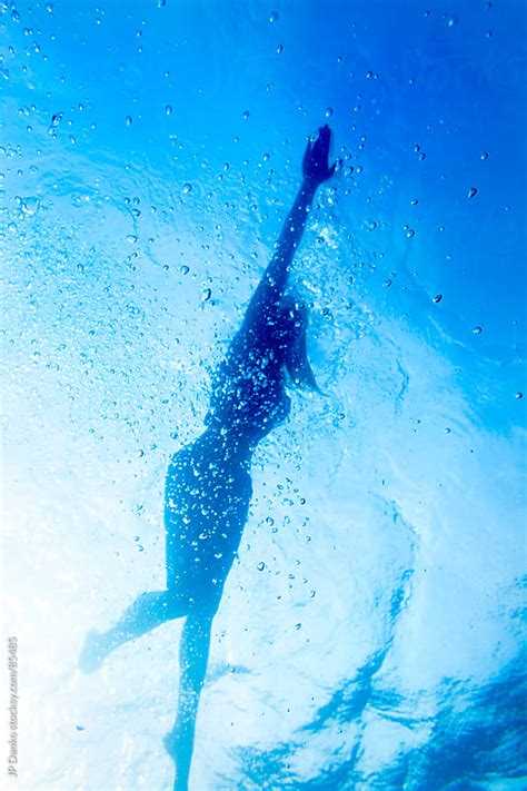 sexy woman in bikini silhouette swimming underwater by jp danko stocksy united
