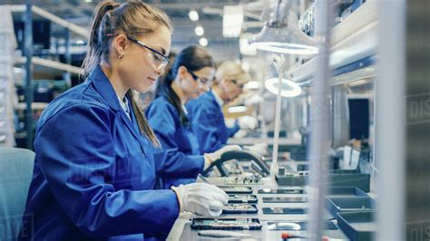 Female Electronics Factory Workers In Blue Work Coat And Protective