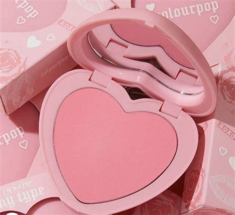 Two Pink Heart Shaped Compacts Sitting On Top Of Each Other In Front Of