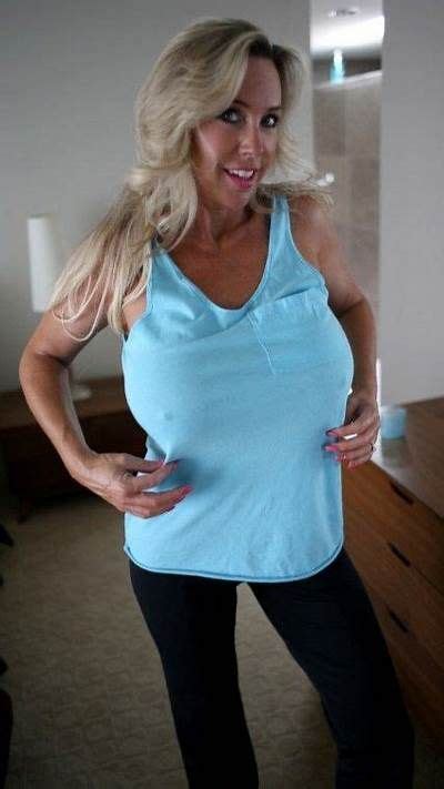 A Woman In Blue Shirt And Black Leggings Posing With Her Hands On Her Hips