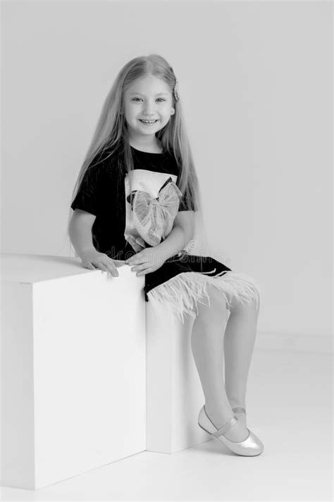 Little Girl Poses For A Magazine In The Studio On A White Cube Stock