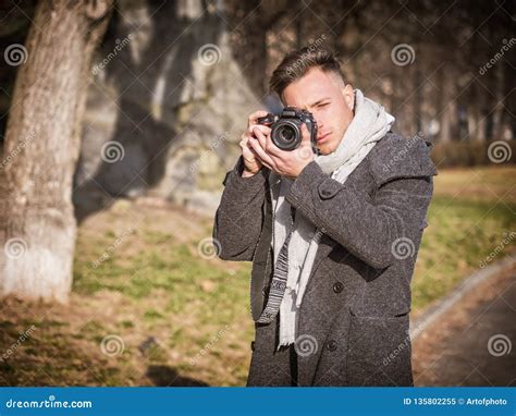 Handsome Young Male Photographer Taking Photograph Outside Stock Image