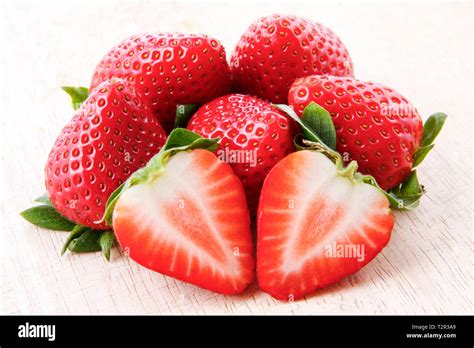 Close Up Of One Cut Strawberry On A Pile Of Fresh Ripe Strawberries