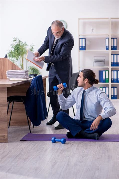 Two Employees Doing Physical Exercises At Workplace Stock Photo Image